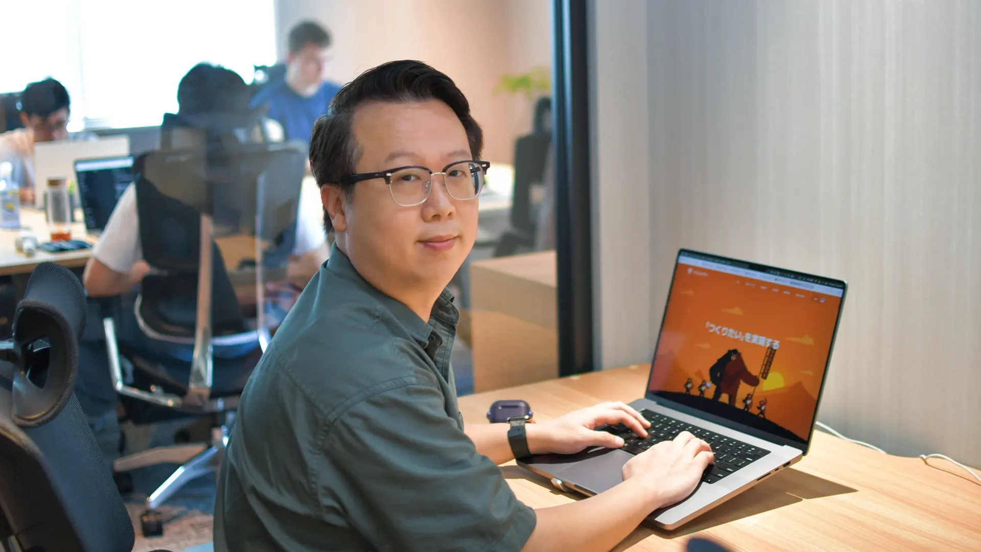 デスクからこちらを見ているジェイソン